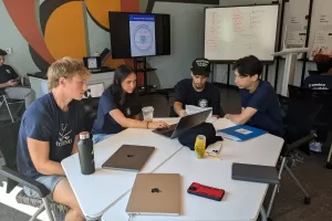 CareLab Student collaborate at a table with laptops