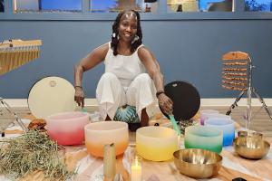 Selena Cozart surrounded by sound bath bowls.