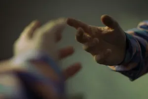 Two hands reaching toward each other