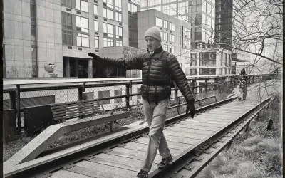 Man walking while balancing on one side of an old railroad track in a sitting