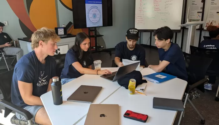 CareLab Student collaborate at a table with laptops