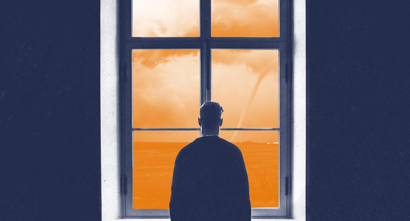 shadow of person standing at window looking out at a desolate orange landscape with a tornado