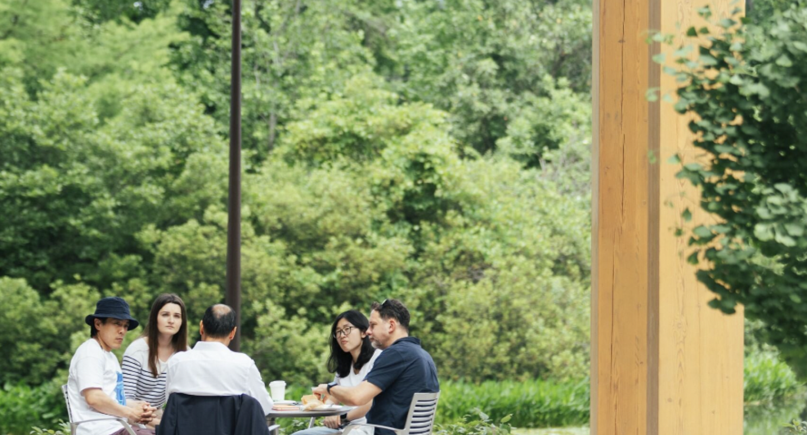 People sitting around a table in the Commons courtyard holding a pensive discussion