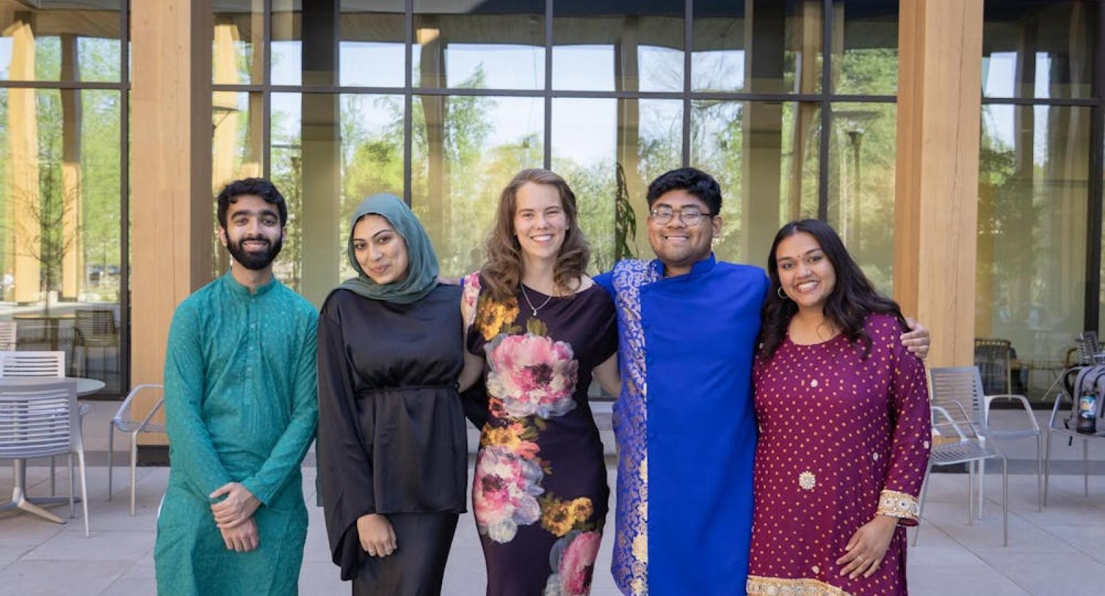 Participants of the interfaith dinner pose with arms around each other