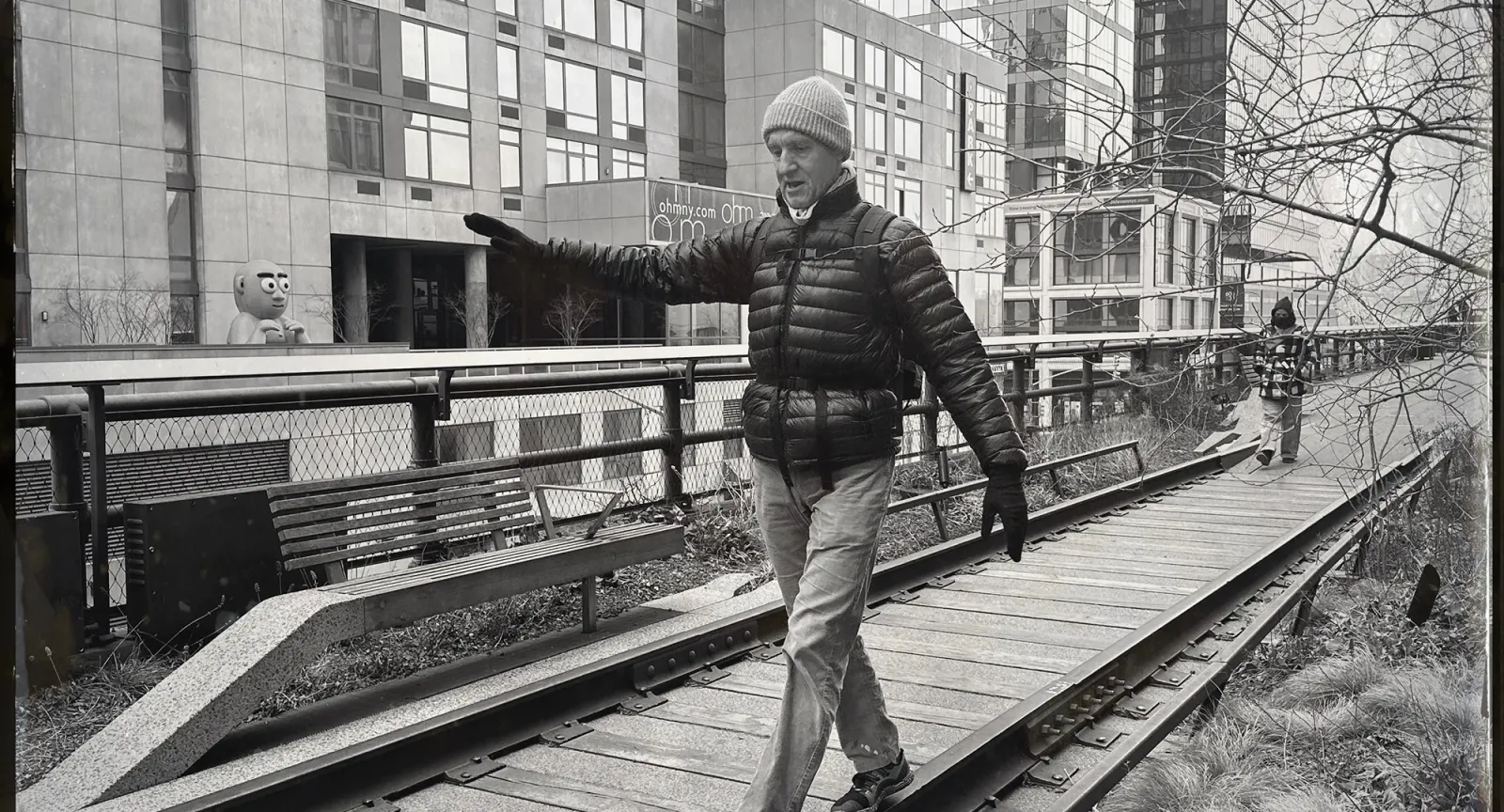 Man walking while balancing on one side of an old railroad track in a sitting