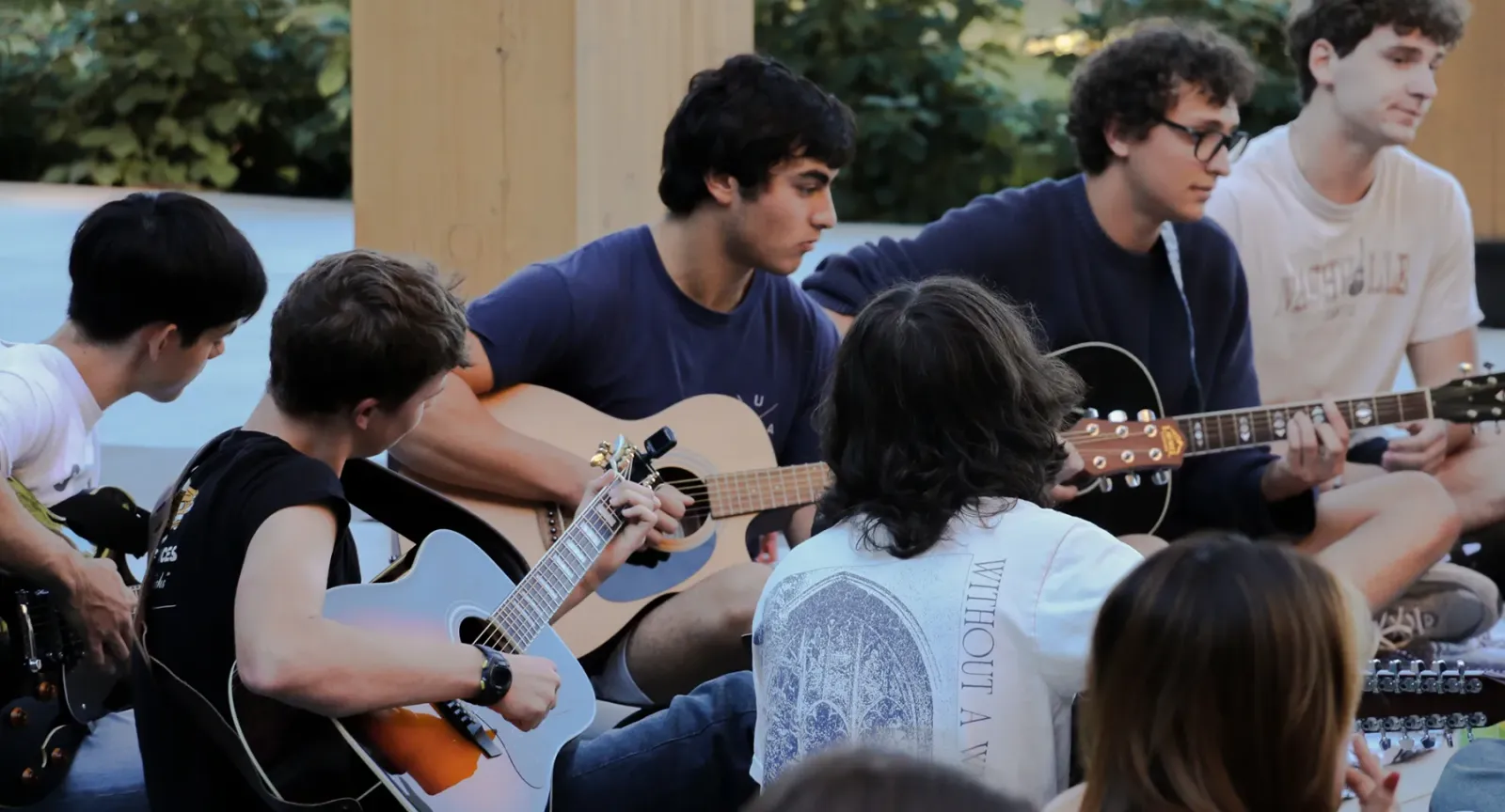 Students playing guitars together in the Contemplative Commons’ Gingko Garden