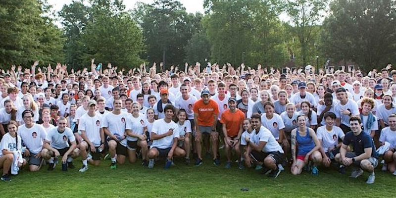 A large group of UVA students pose with President Jim Ryan before a Run with Jim event
