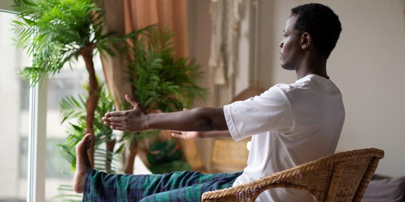 Person doing chair yoga in their home by a window
