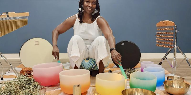 Selena Cozart surrounded by sound bath bowls.