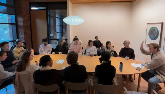 Students around a table discussing yoga with John Bultman