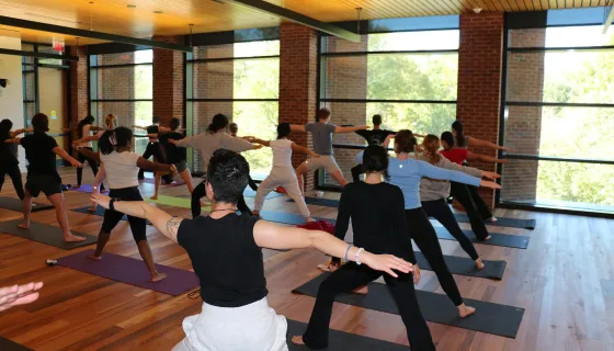 A yoga class in the Contemplative Commons, students in the Hero Pose