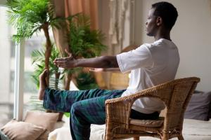 Person doing chair yoga in their home by a window