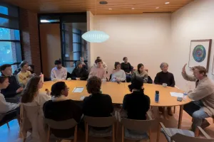 Students around a table discussing yoga with John Bultman