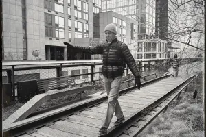 Man walking while balancing on one side of an old railroad track in a sitting