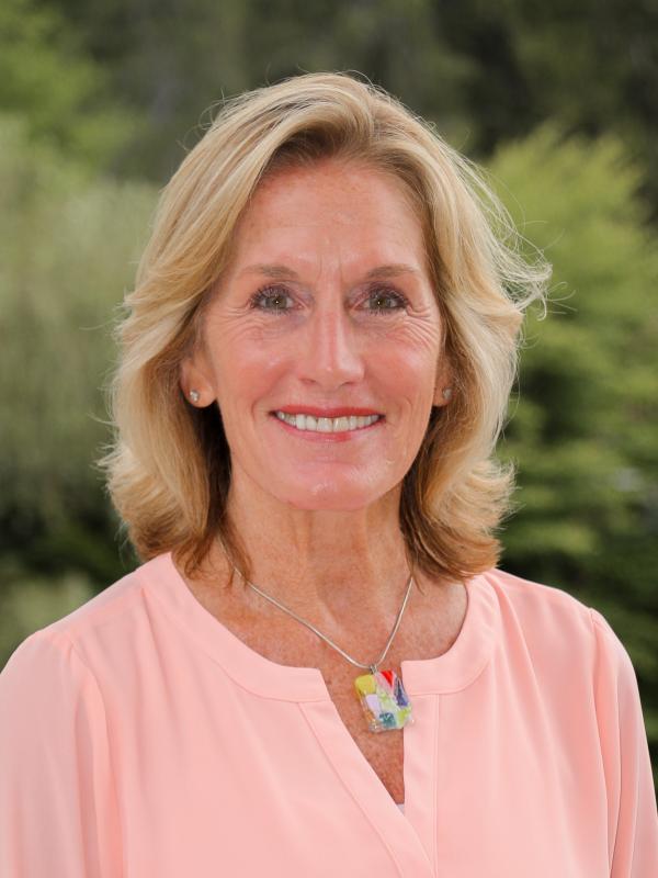 Cecelia Magargee's headshot, taken on the balcony of the third floor of the Contemplative Commons with greenery visible in the background. 