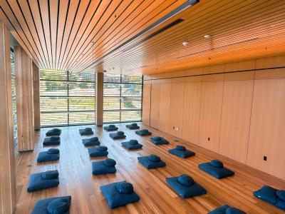 Empty cushions in rows placed in rows inside a Contemplative Commons classroom. 