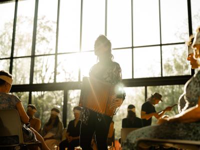 Musician play accordian during a Golden Hour with participants blindfolded.
