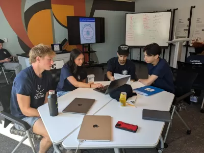 CareLab Student collaborate at a table with laptops