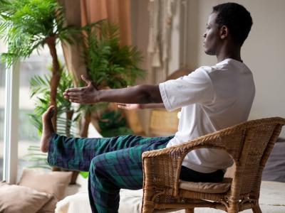 Person doing chair yoga in their home by a window