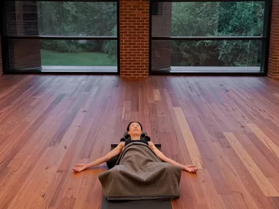 A person doing yoga nidra on the floor in room in the Contemplative Commons