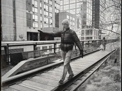 Man walking while balancing on one side of an old railroad track in a sitting